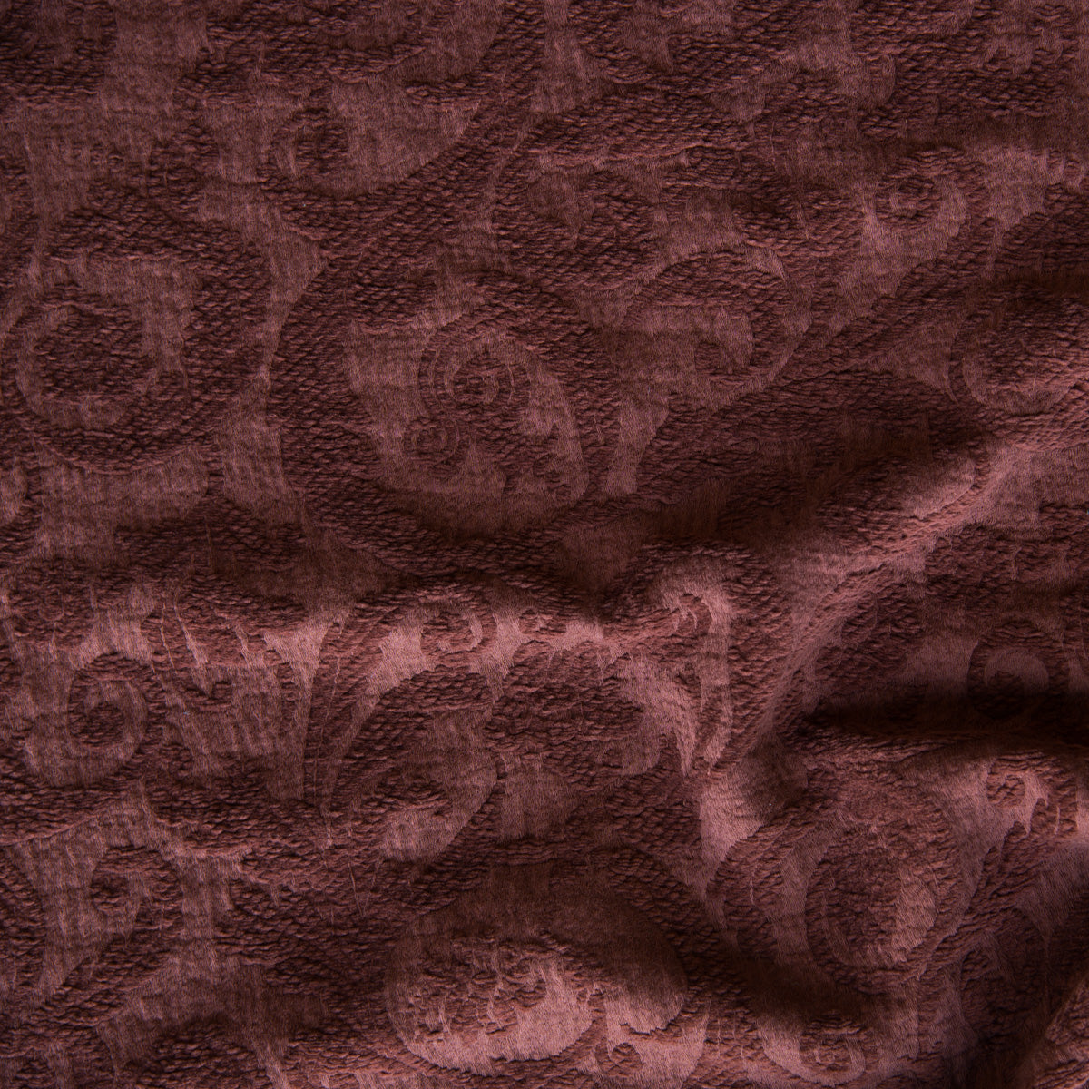 Mahogany: A close up of Adele fabric in mahogany, a deep, earthen, reddish brown. The fabric is rumpled to show the cotton damask texture.