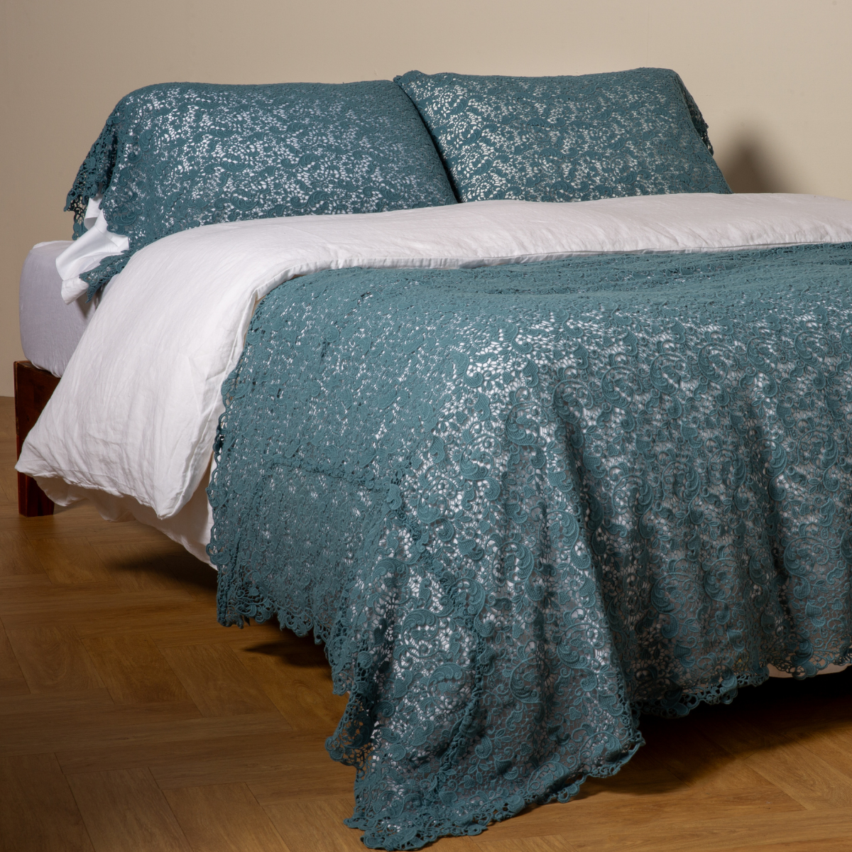 Cenote: cotton lace bed scarf draped across the foot of a bed dressed in linen sheets and duvet cover in winter white - shown with matching lace pillowcase covers over a linen liner in winter white.