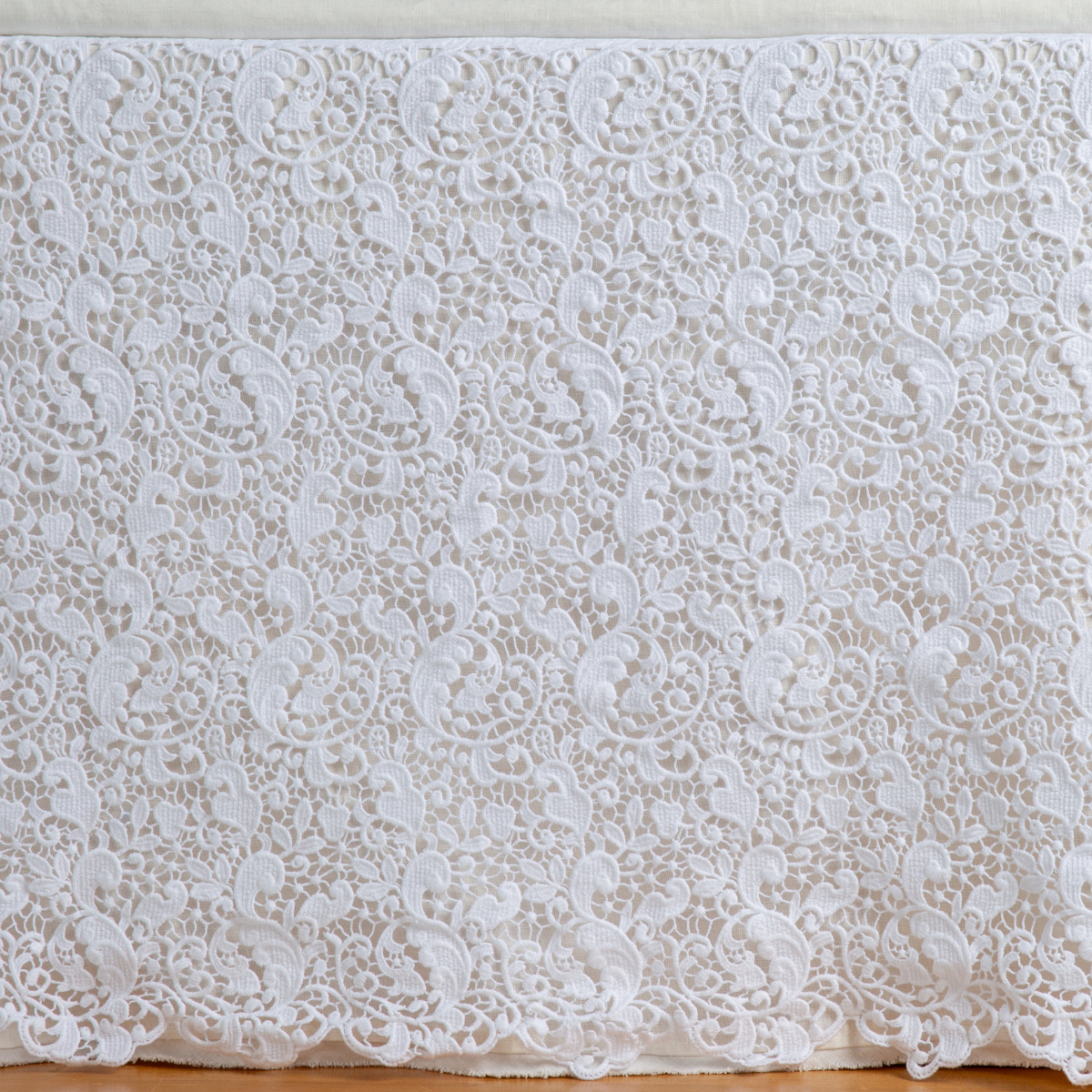 White: a close up of a cotton lace bed skirt layered over a winter white bed skirt - shot straight at the bed skirt.
