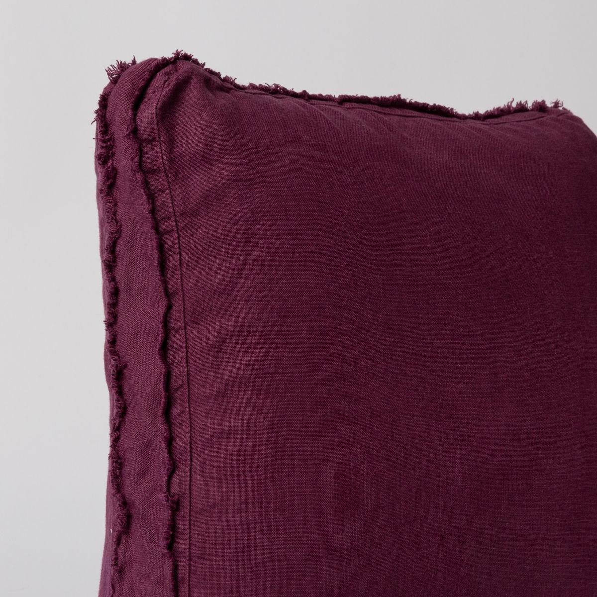 Fig: close up of midweight linen pillow corner with raw edges trimming its gusset.