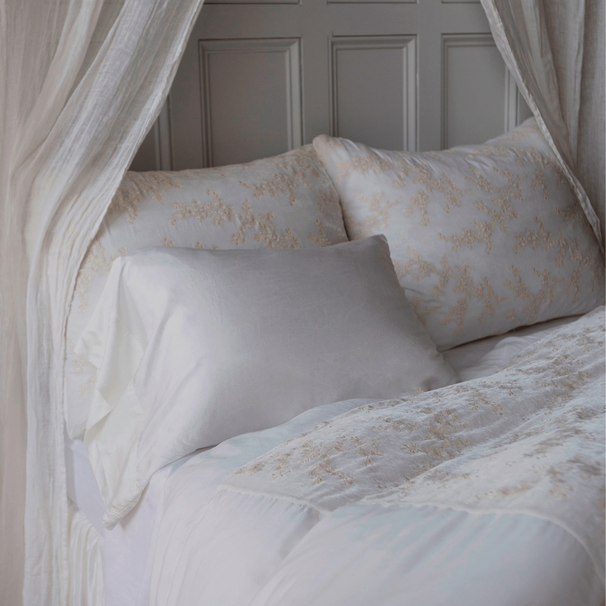 Winter White: duvet cover and matching shams shown with a silk and tencel™ pillowcase and white sheets — lighweight gauze curtain panels are draped around the head of the bed.