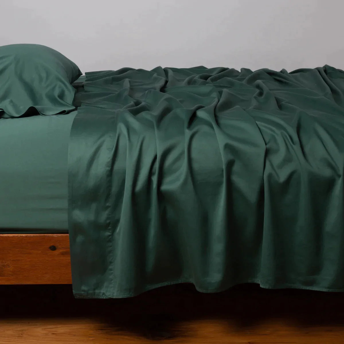 Jade: Cotton sateen flat sheet, shown with matching fitted sheet and sleeping pillow - side view.