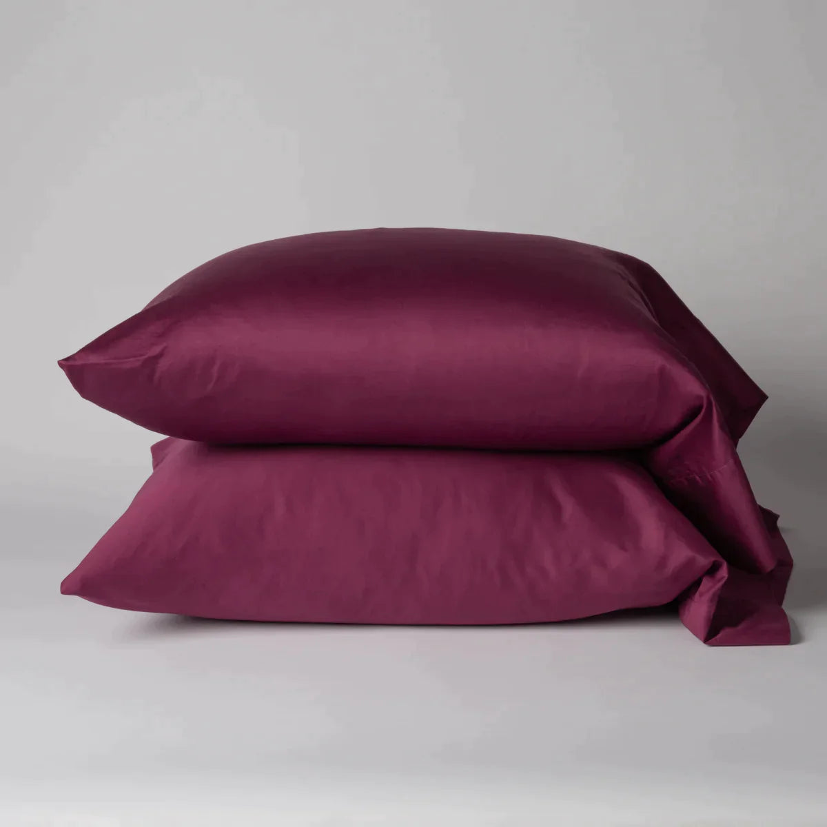 Fig: Two cotton sateen sleeping pillows, stacked neatly against a white backdrop - side view.