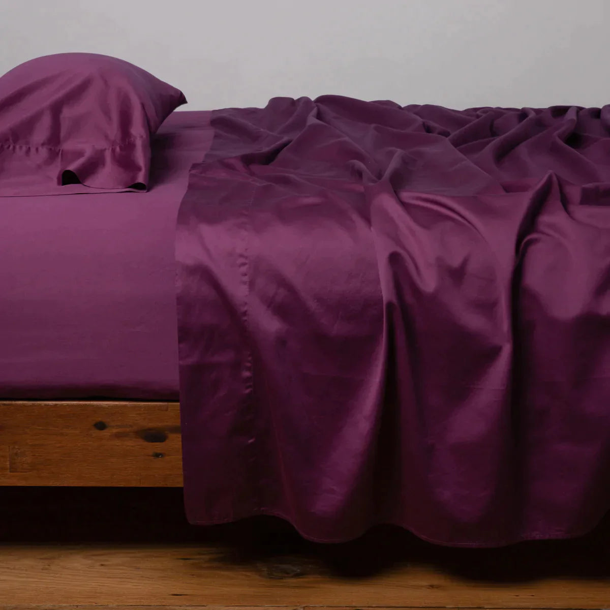 Fig: Cotton sateen sleeping pillow, on a bed with matching sheets - side view.