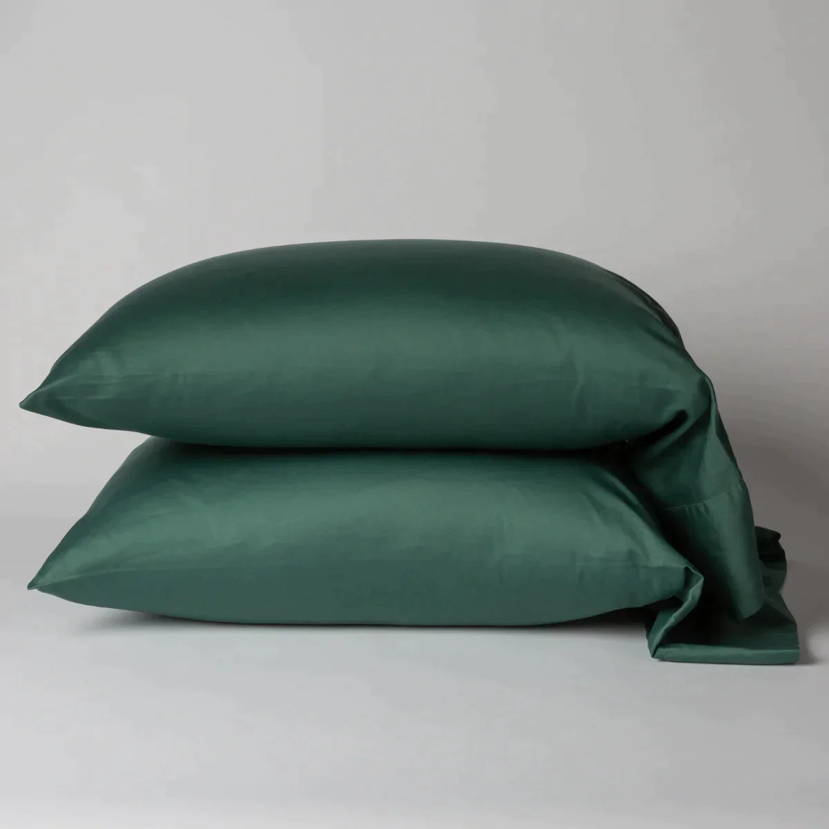Jade: Two cotton sateen sleeping pillows, stacked neatly against a white backdrop - side view.