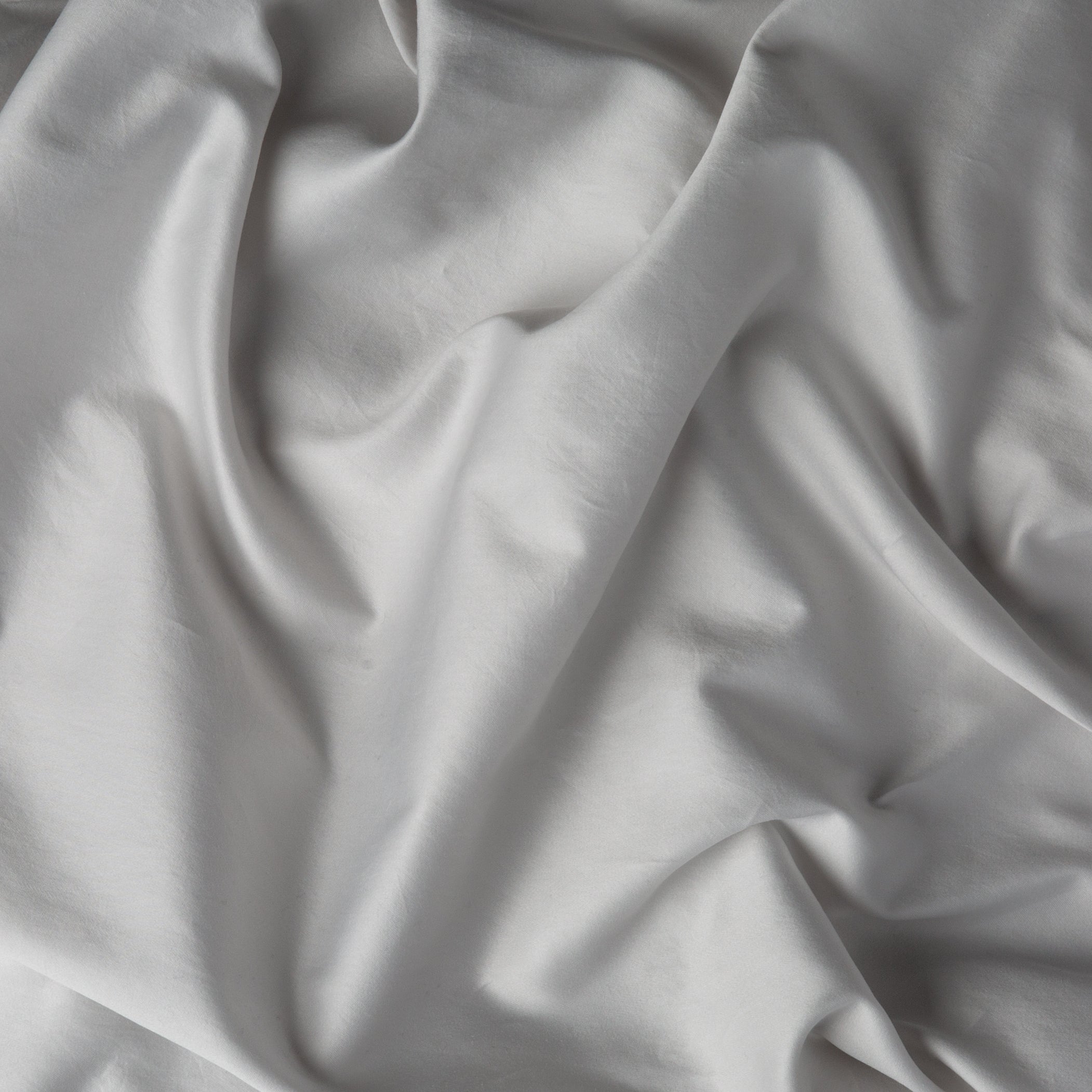 A close up of cotton sateen fabric in sterling, a silvery neutral light grey.
