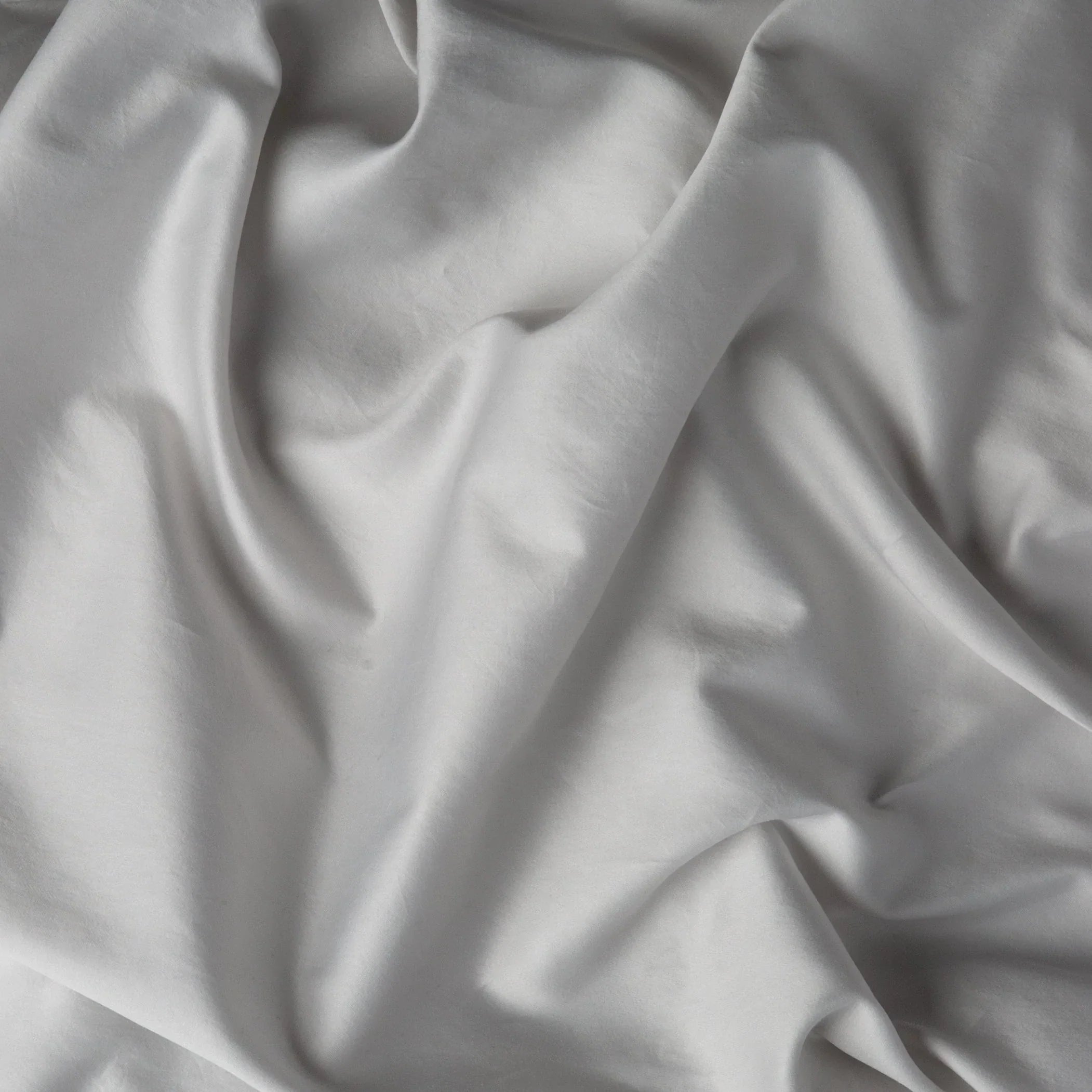 Sterling: A close up of cotton sateen fabric in sterling, a silvery neutral light grey.