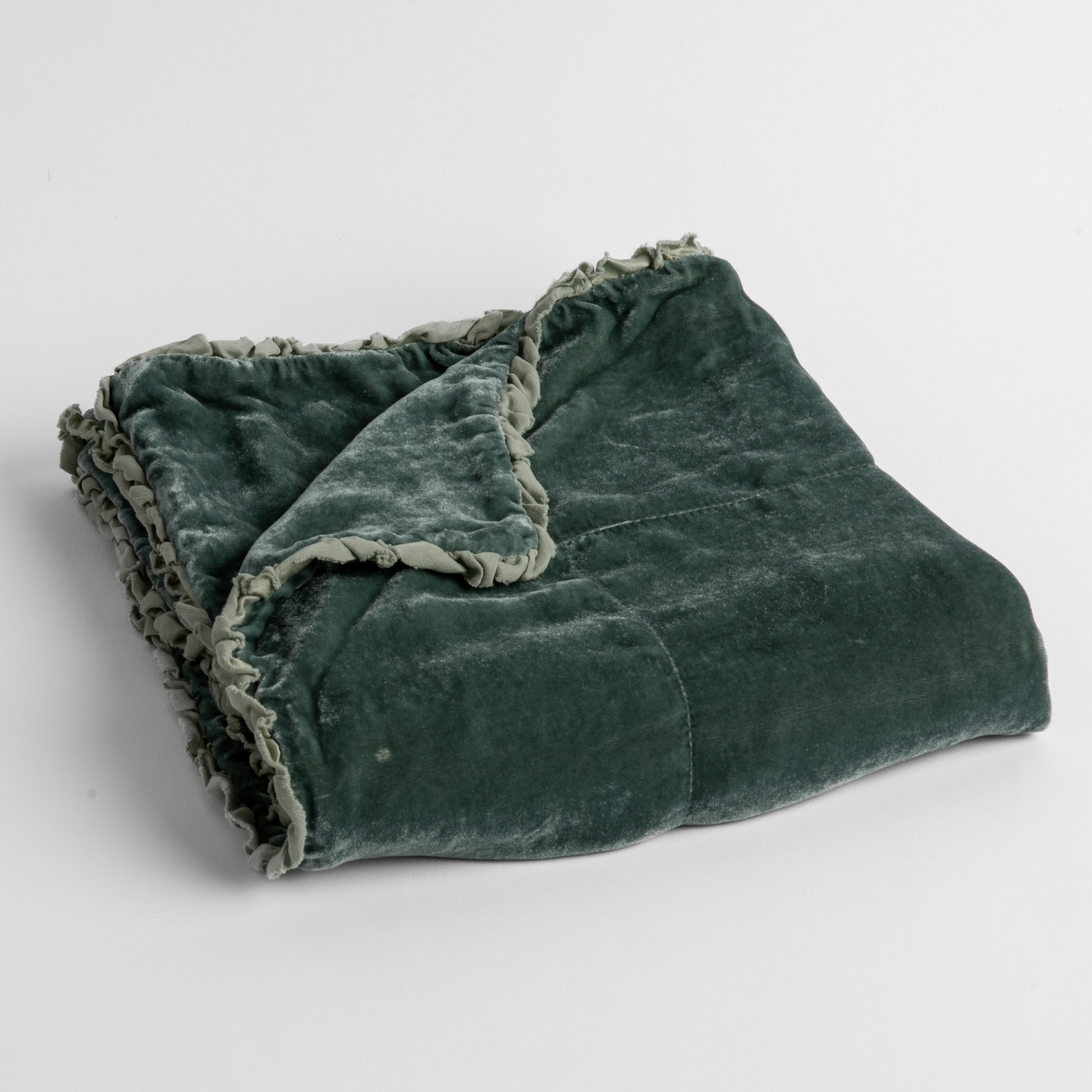 Eucalyptus: silk velvet baby blanket with charmeuse trim shown slightly overhead with a corner folded back to show trim detail against a white background.