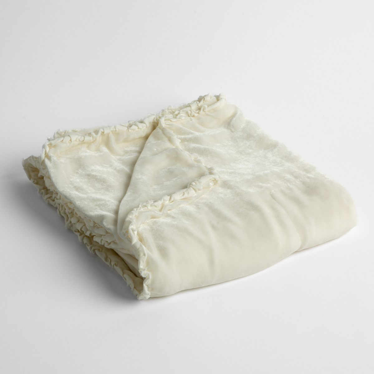 Winter White: silk velvet baby blanket with charmeuse trim shown slightly overhead with a corner folded back to show trim detail against a white background.