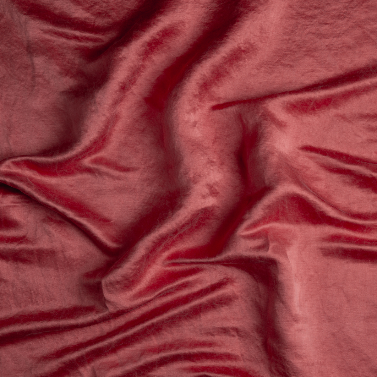 Poppy: A close up of charmeuse fabric in poppy, a warm coral pink.