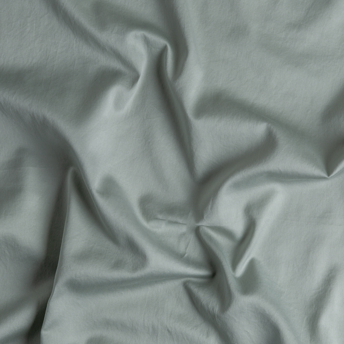 Eucalyptus: A close up of cotton sateen fabric in eucalyptus, a soft light green.