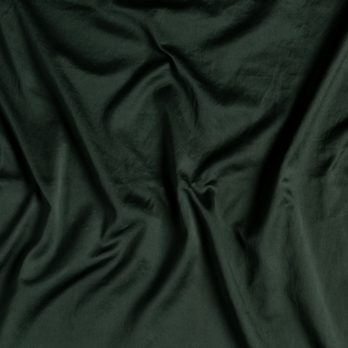 Juniper: A close up of cotton sateen fabric in Juniper, a deep green tone.