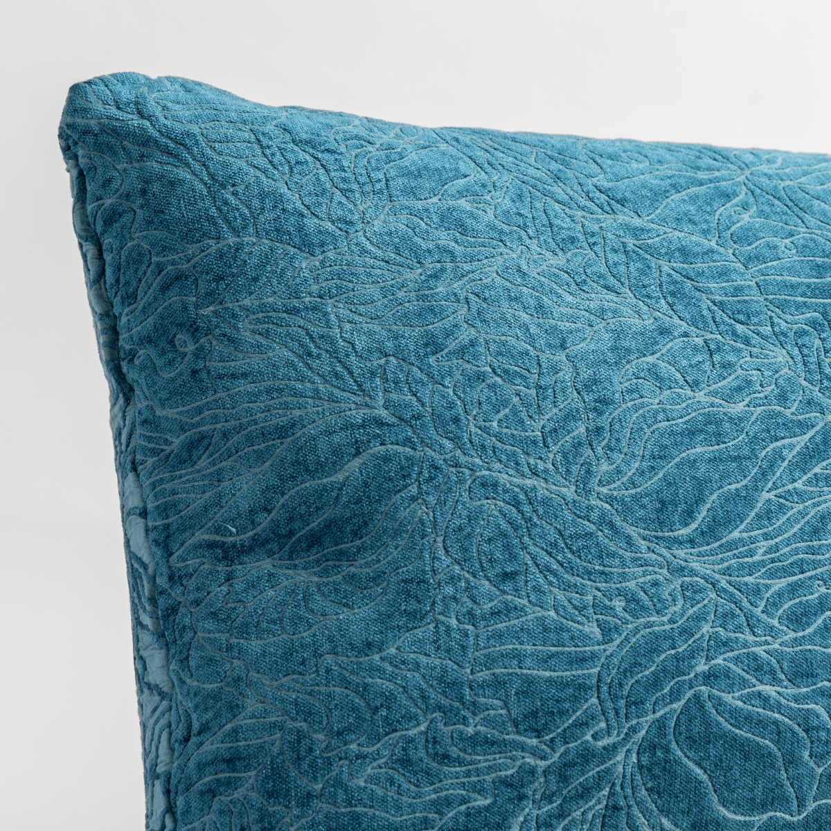 Cenote: close up of the chenille jacquard corner of a pillow cushion with a single-line floral pattern.