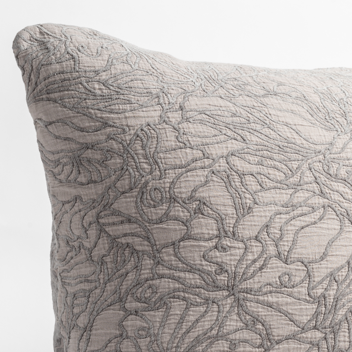 Moonlight: close up of the cotton jacquard corner of a pillow cushion with a single-line floral pattern.