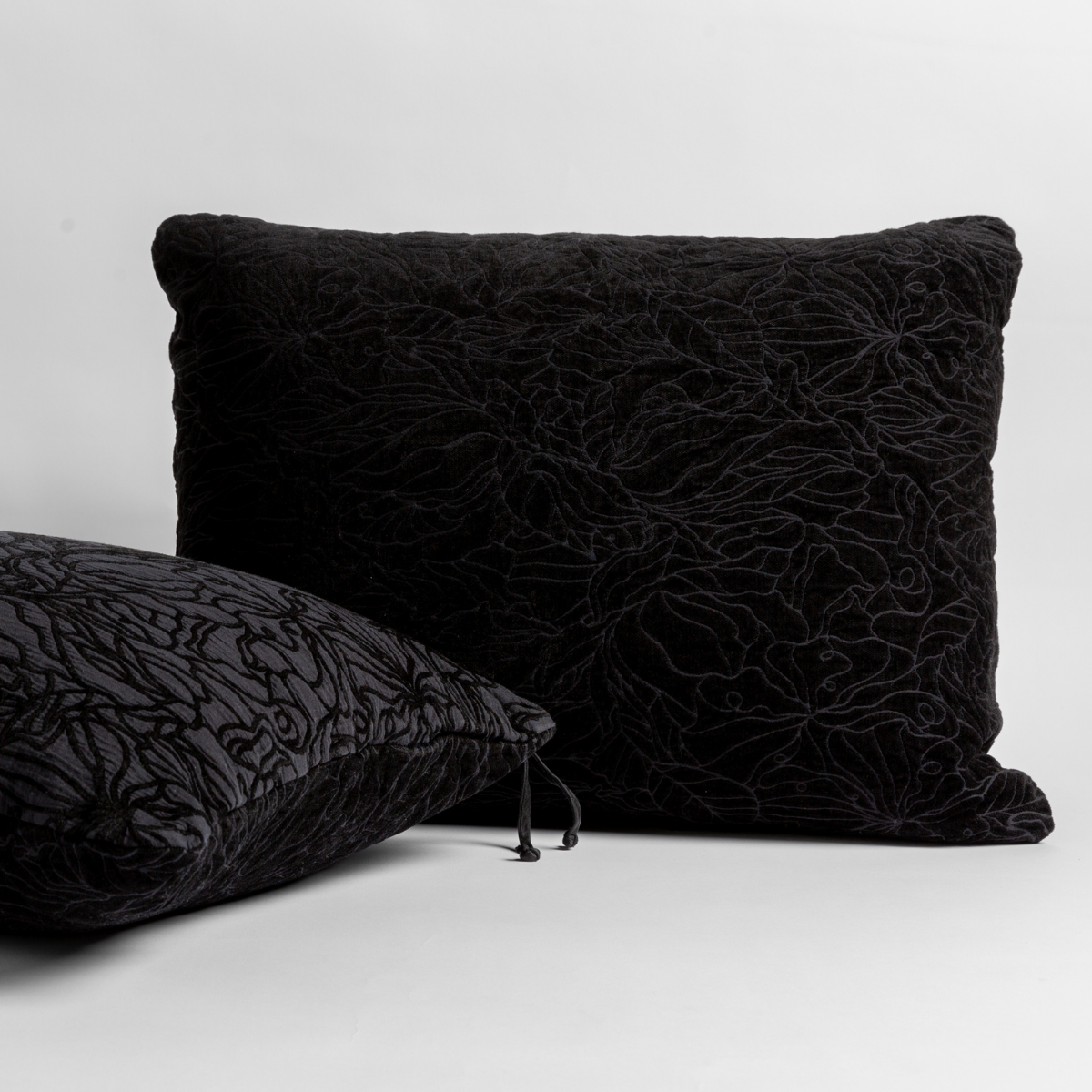 Corvino: pair of shams shown against a white background show the chenille and cotton jacquard faces and floral motif.