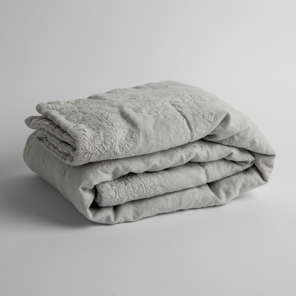 Cloud: embroidered linen baby blanket folded and shown overhead from a slight angle against a white background.