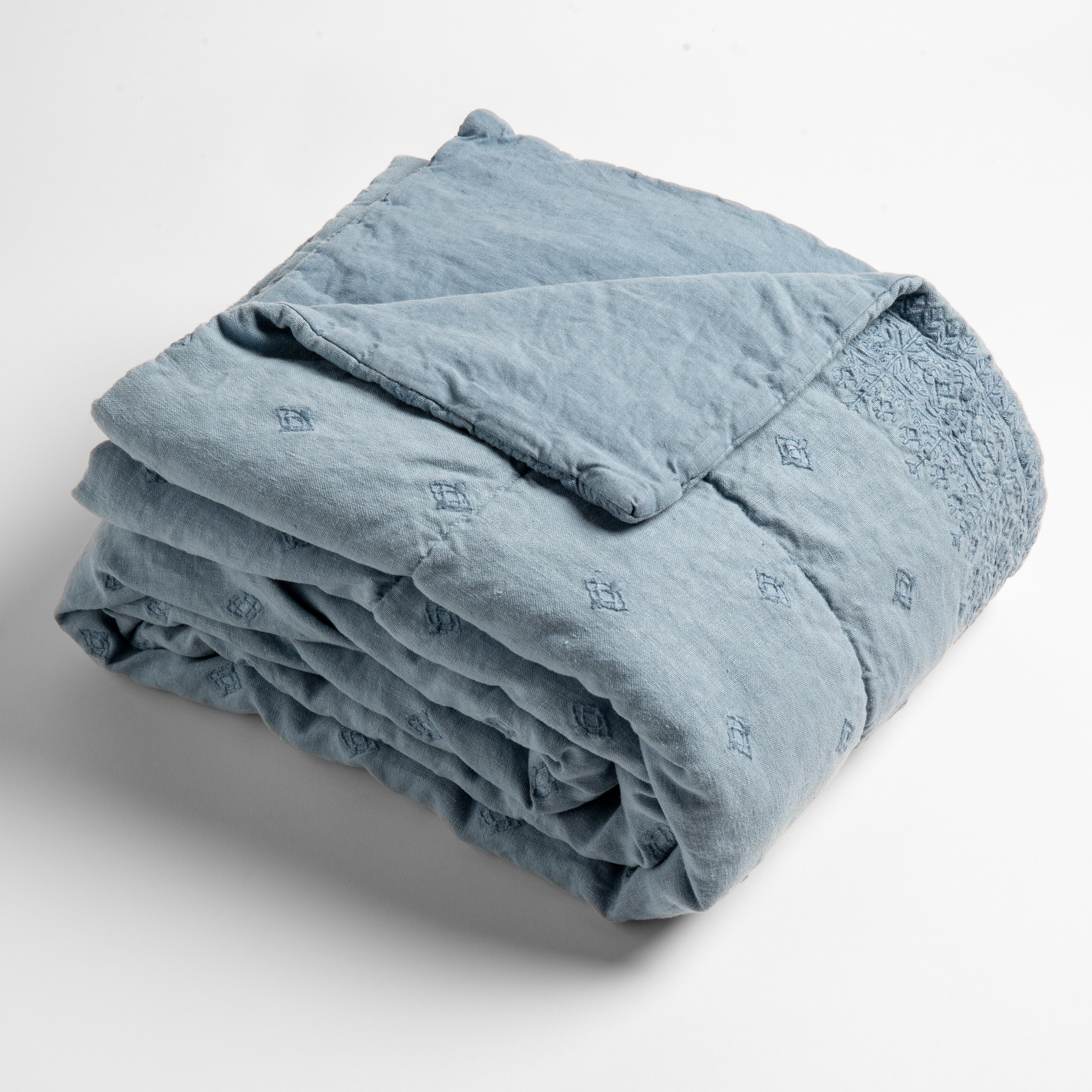 Tahoe Blue: embroidered linen baby blanket folded and shown overhead from a slight angle against a white background.