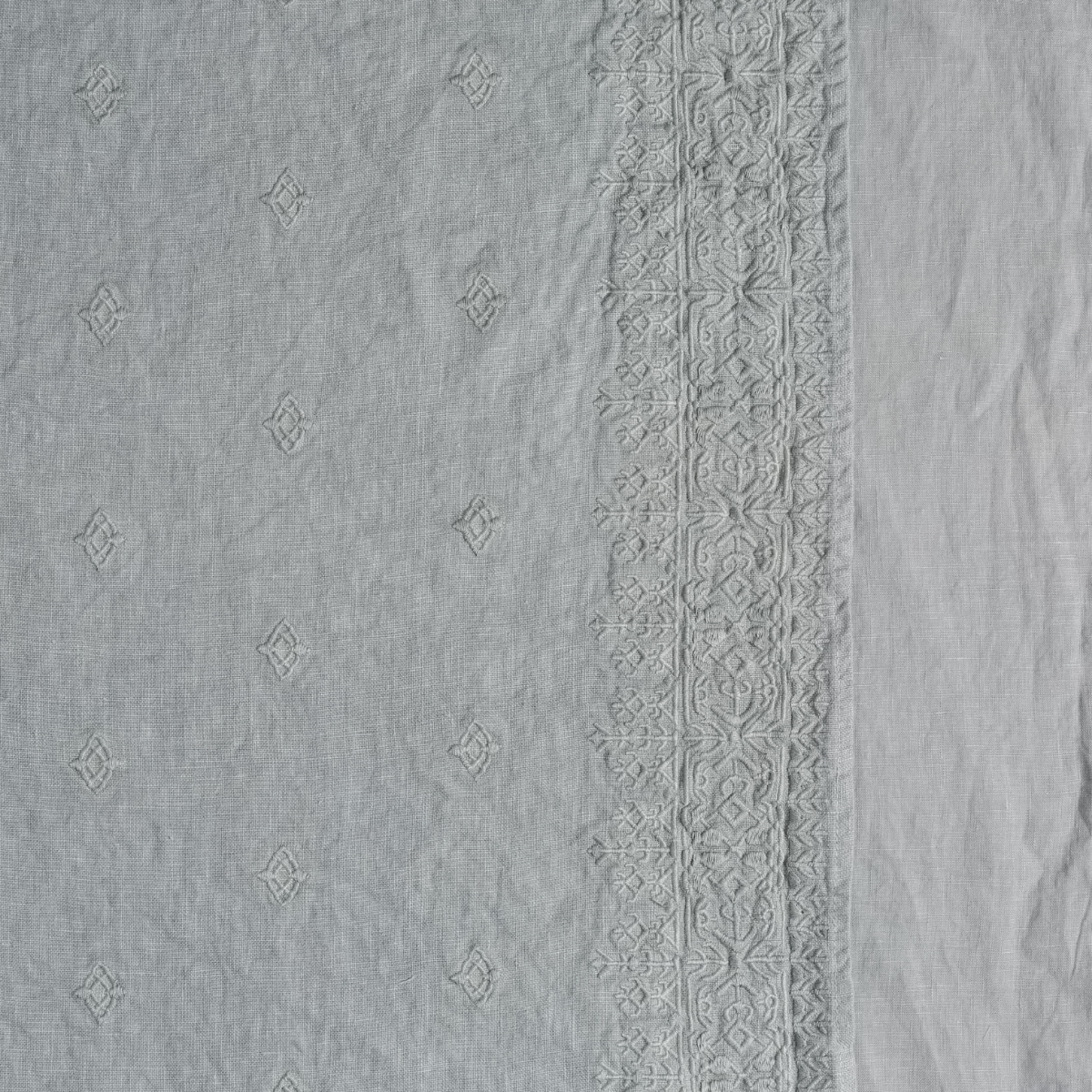 Mineral: A close up of embroidered midweight linen fabric in mineral, a soothing seafoam blue with subtle grey-green undertones.