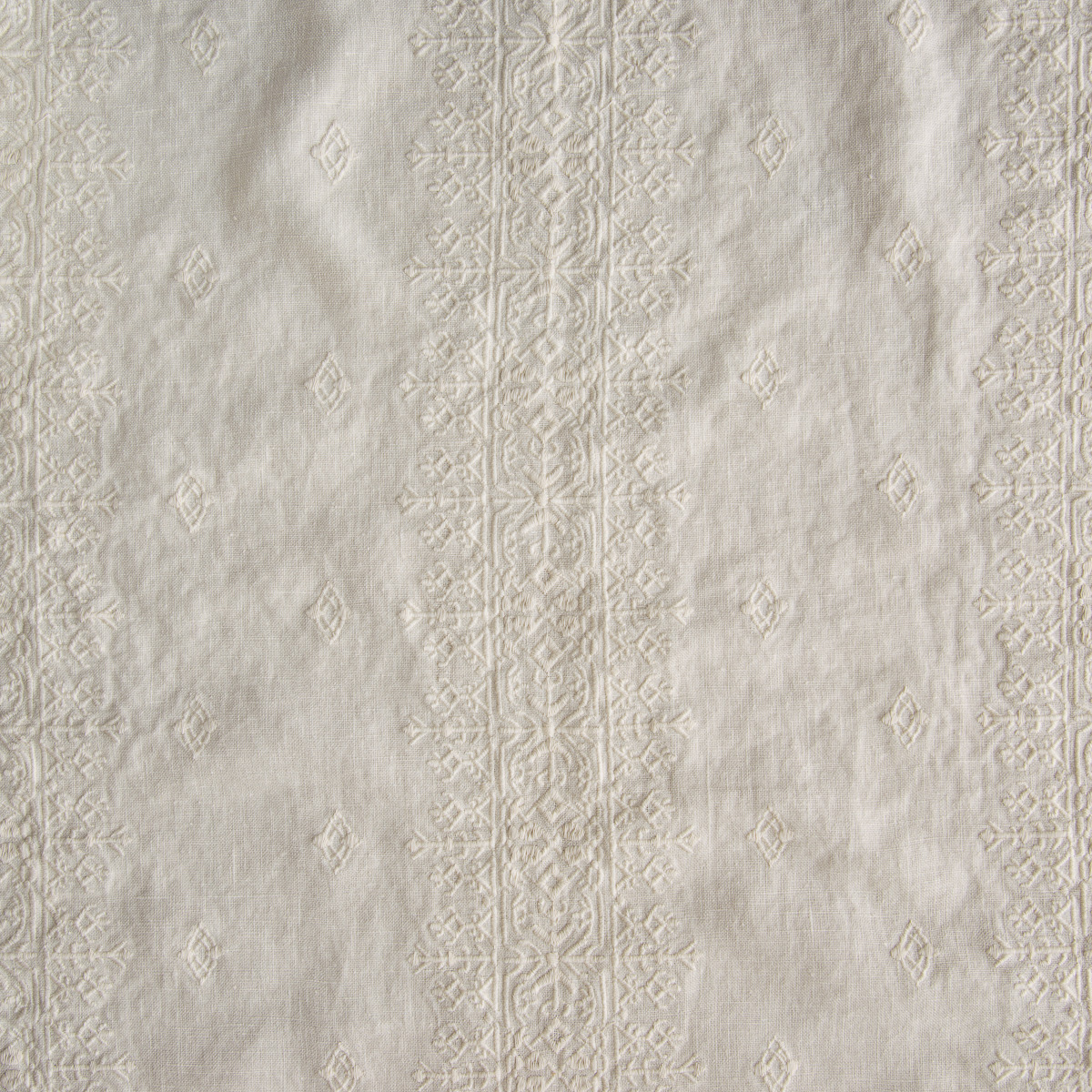 Parchment: A close up of embroidered midweight linen fabric in parchment, a warm, antiqued cream.
