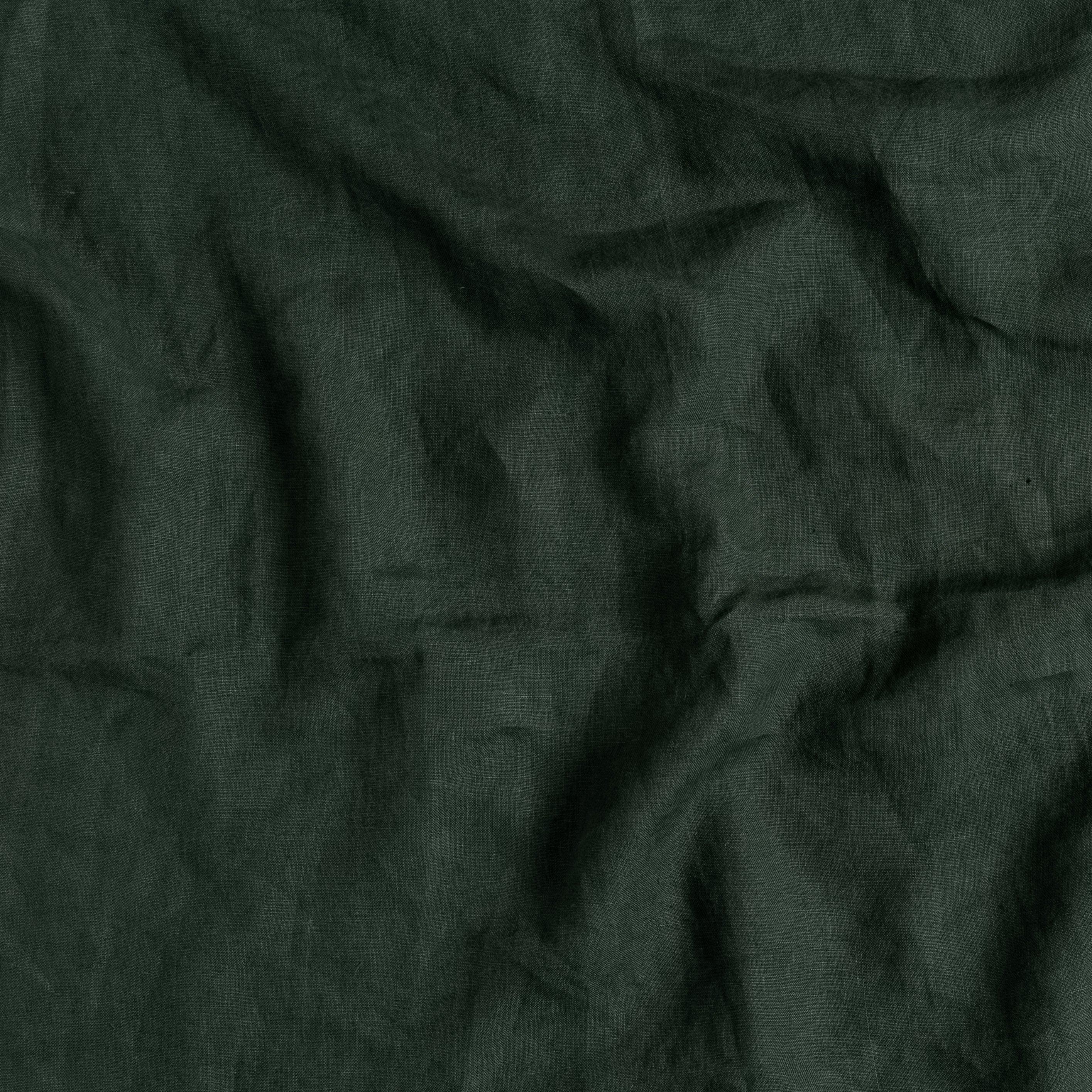 A close up of linen fabric in juniper, a deep green shade, and gently rumpled.