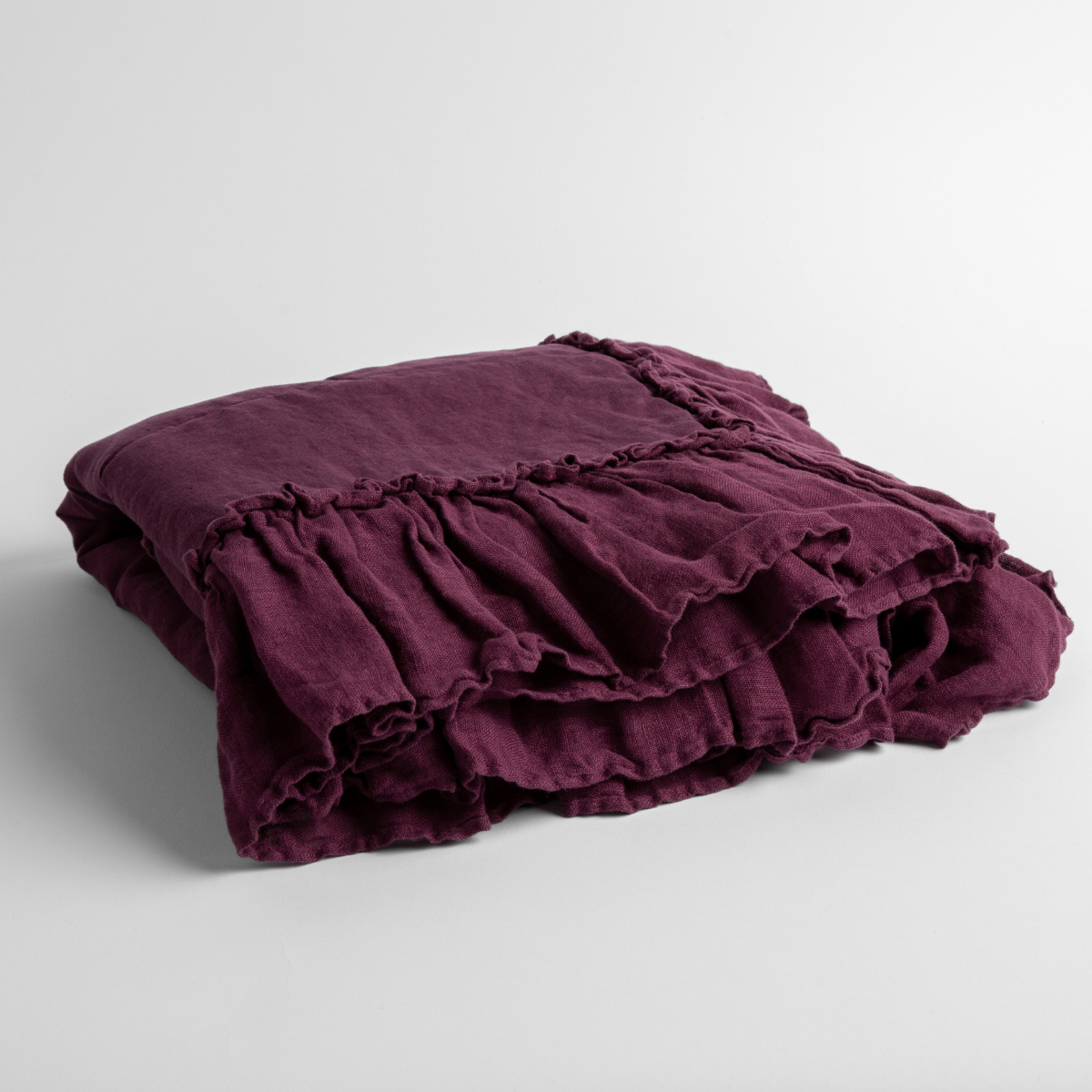 Fig: a folded linen with linen whisper ruffled blanket folded and positioned to show the ruffle detail against a white background and slightly overhead.