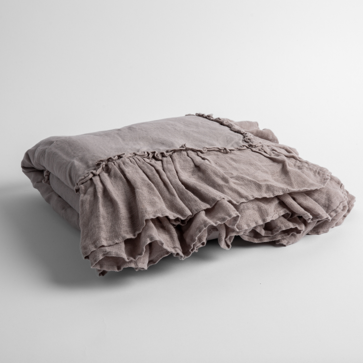 Moonlight: a folded linen with linen whisper ruffled blanket folded and positioned to show the ruffle detail against a white background and slightly overhead.