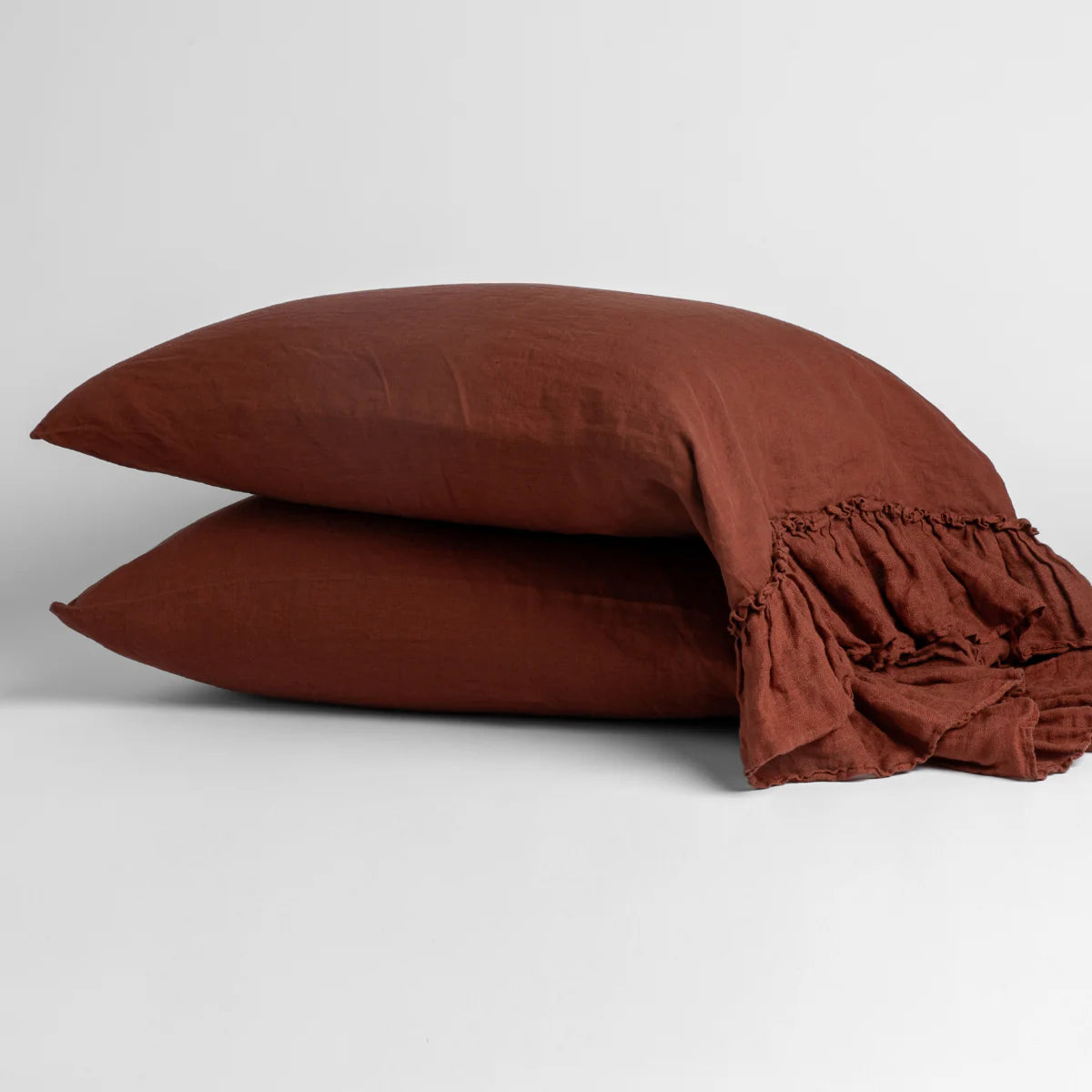 Autumn: Two sleeping pillows stacked at a slight angle against a plain background, showcasing ruffle trim detail - side view.