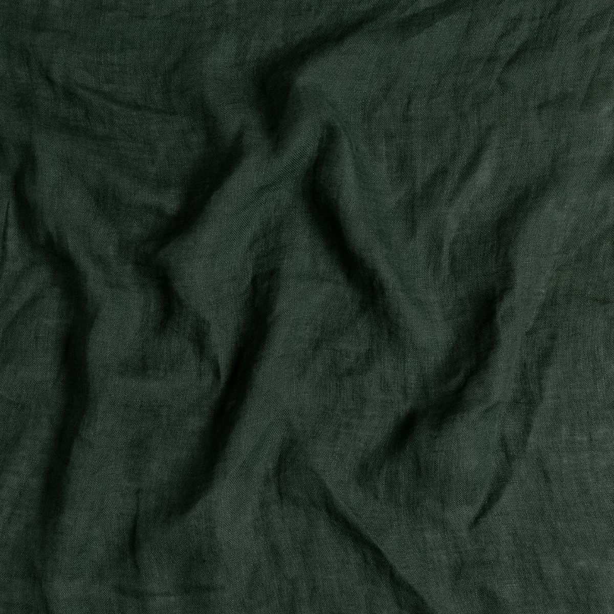 Juniper: A close up of linen whisper fabric in Juniper, a deep green tone.