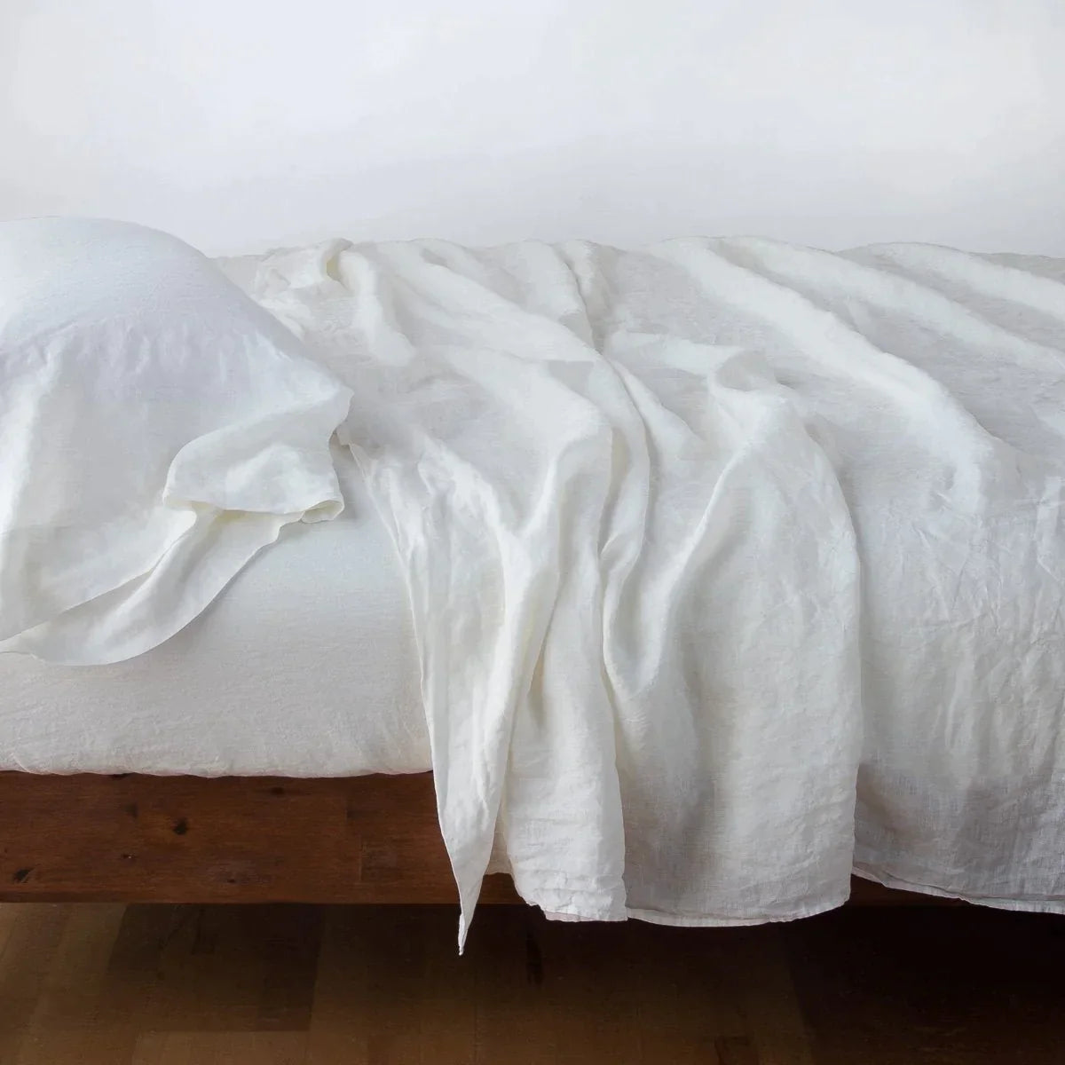 Winter White: Rumpled linen sheeting with matching sleeping pillow - side view.