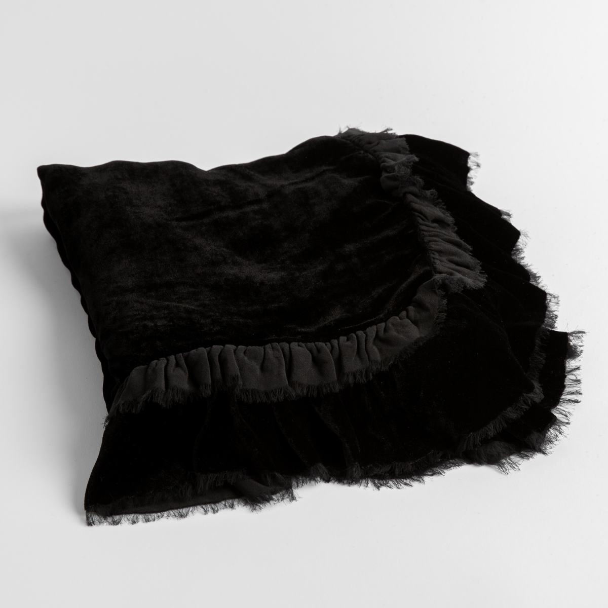 Corvino: an overhead shot of a folded silk velvet baby blanket with a raw-edged eyelash ruffle detail.