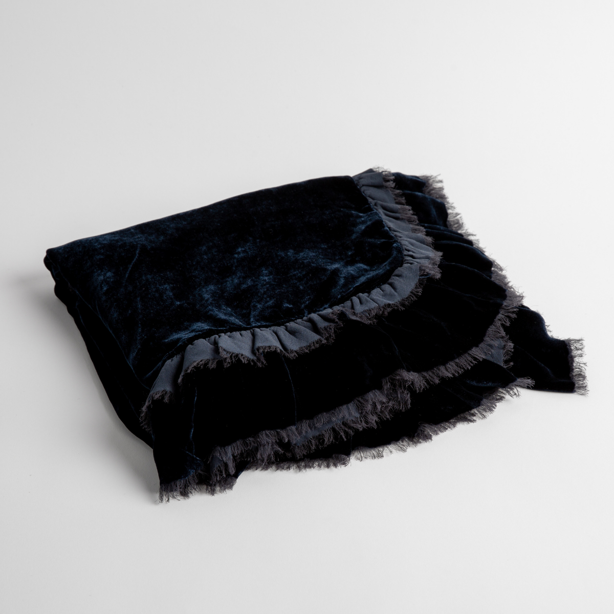 Midnight: an overhead shot of a folded silk velvet baby blanket with a raw-edged eyelash ruffle detail.