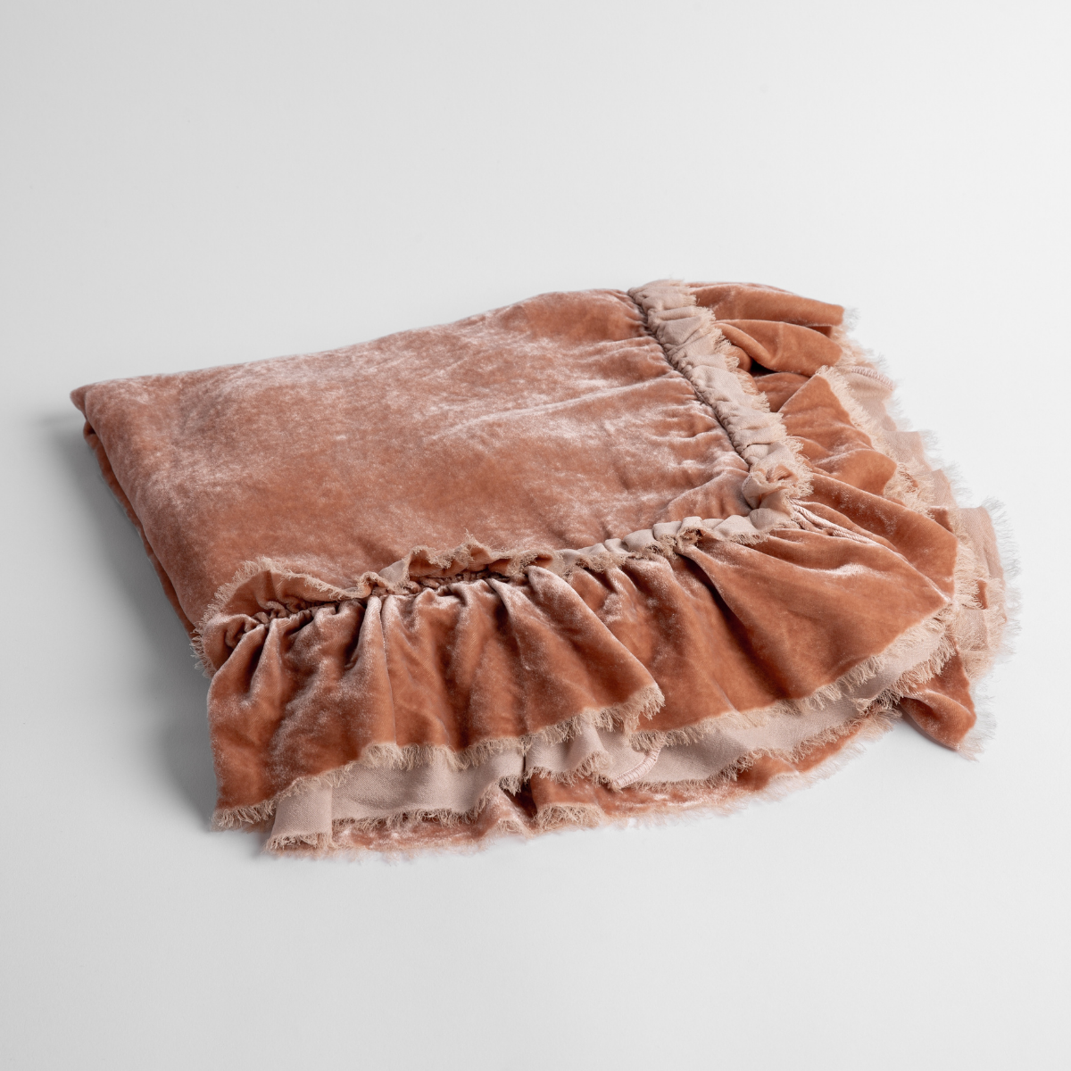 Rouge: an overhead shot of a folded silk velvet baby blanket with a raw-edged eyelash ruffle detail.