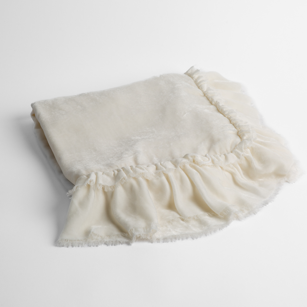 Winter White: an overhead shot of a folded silk velvet baby blanket with a raw-edged eyelash ruffle detail.