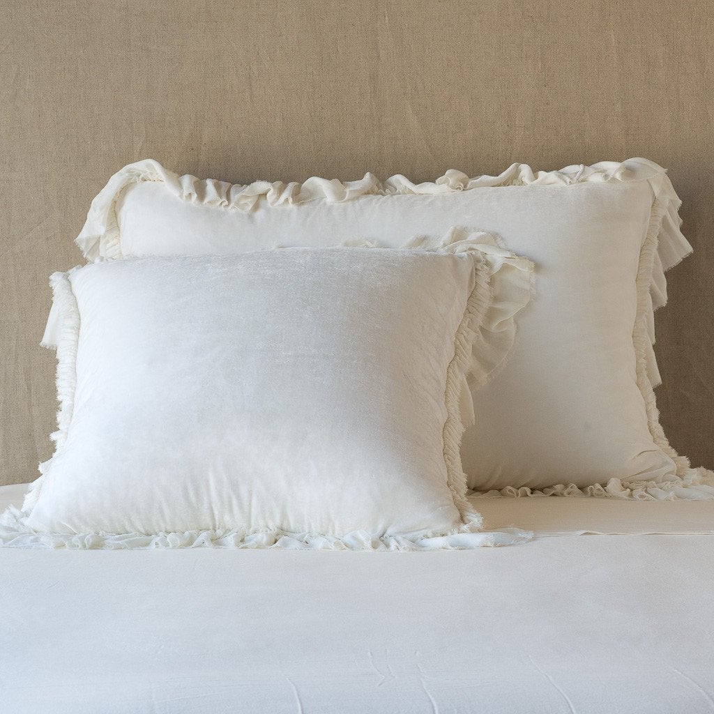Winter White: shams leaning upright on white sheets against a neutral headboard.