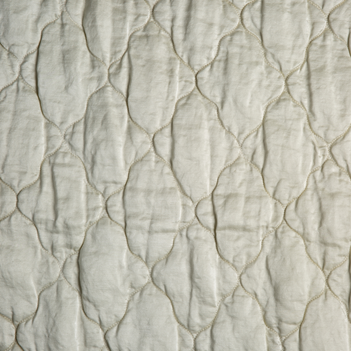Parchment: A close up of quilted charmeuse fabric in parchment, a warm, antiqued cream.