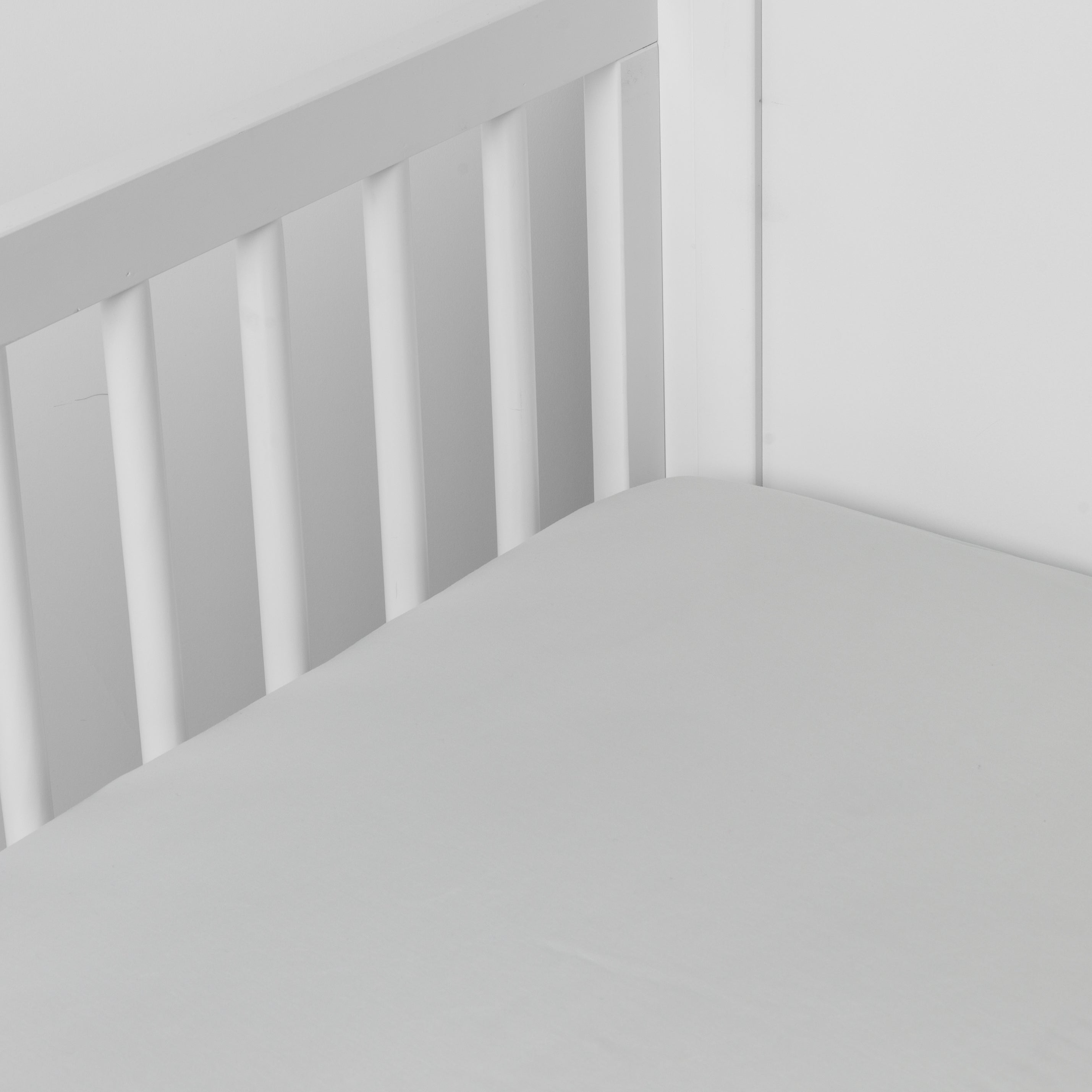 Cloud: crib sheet shown on a mattress shown from overhead into the corner of a crib.