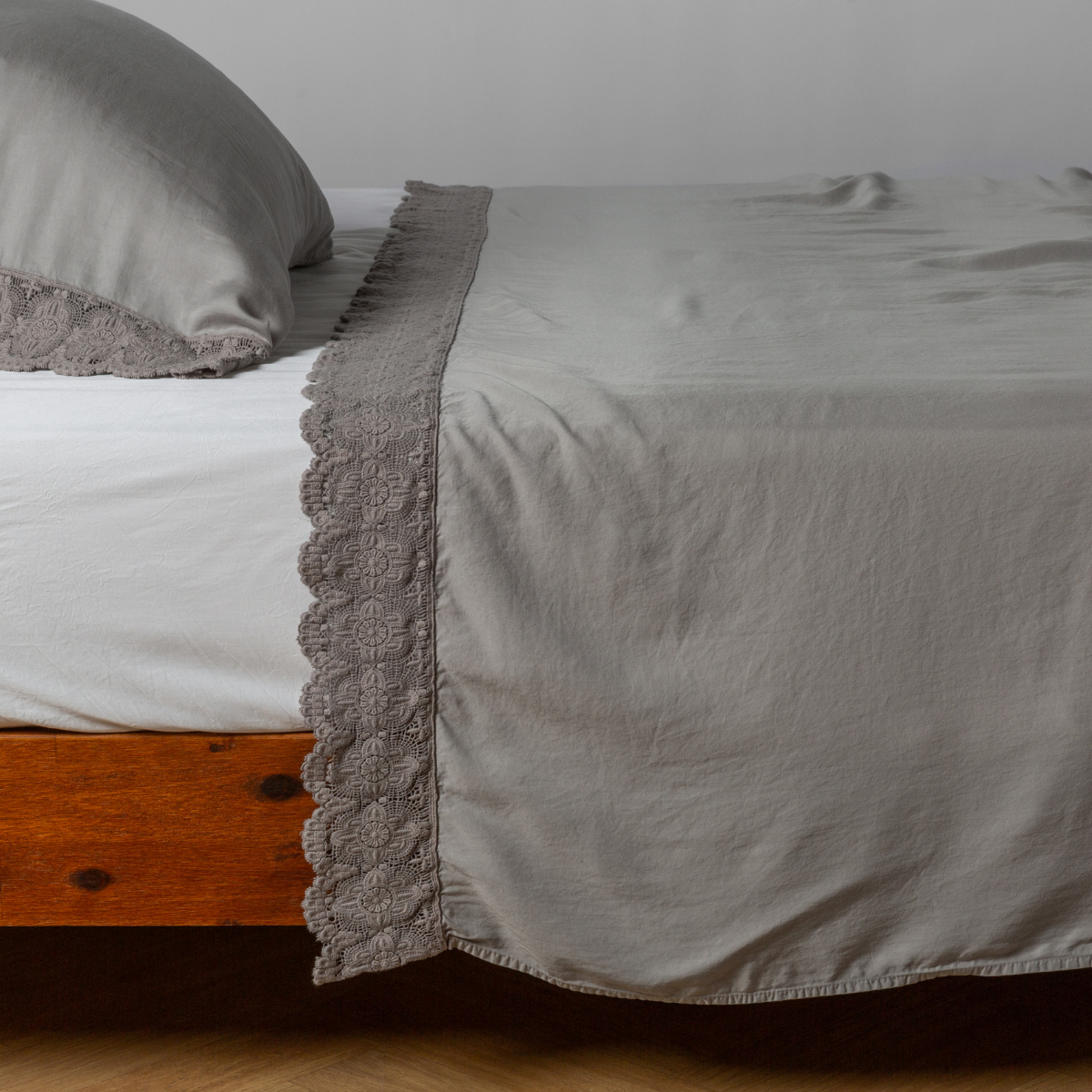 matching cotton lace trimmed flat sheet and pillowcase shown with simple white sheet - side view.