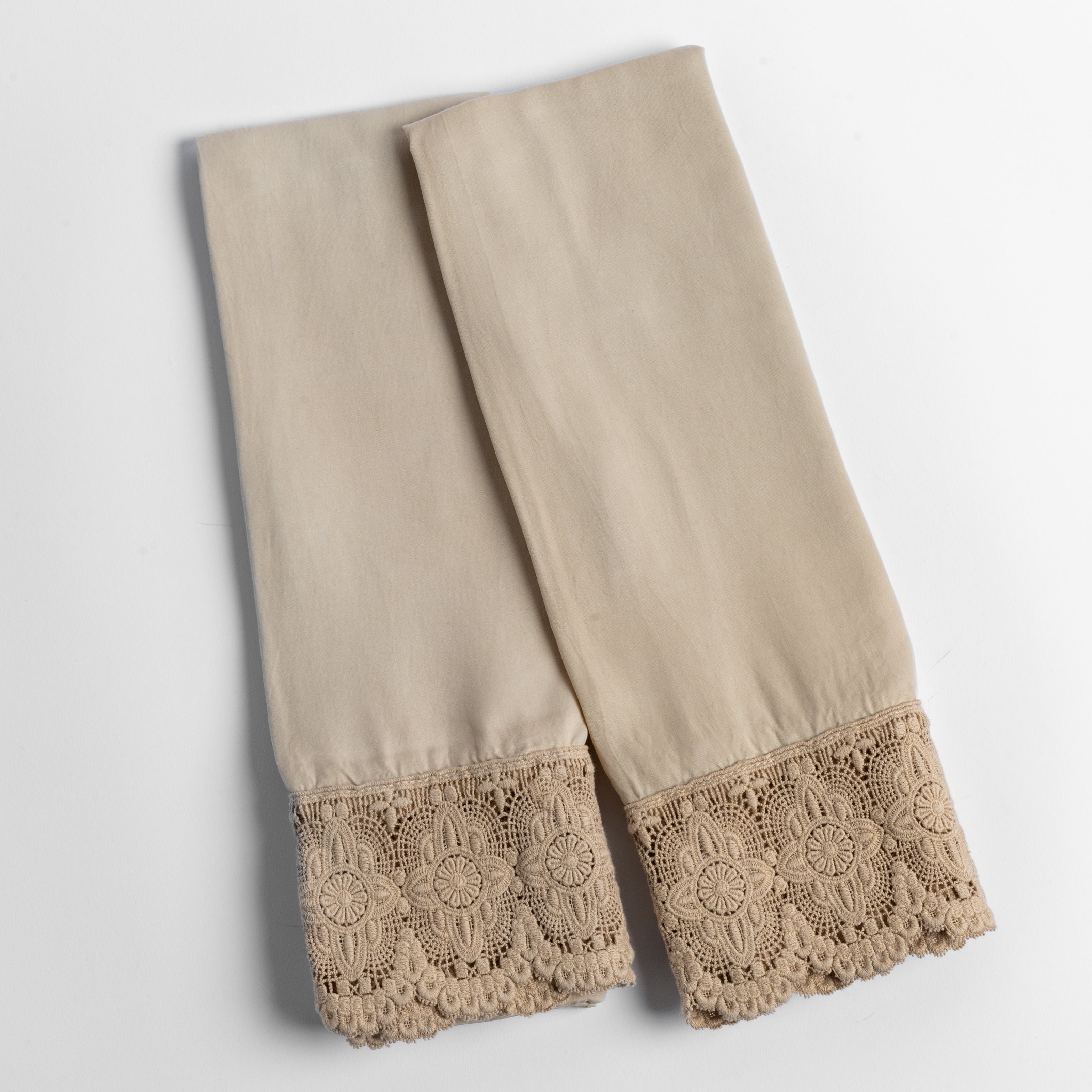 cotton lace trimmed tencel pillowcases folded and shot from overhead against a white background