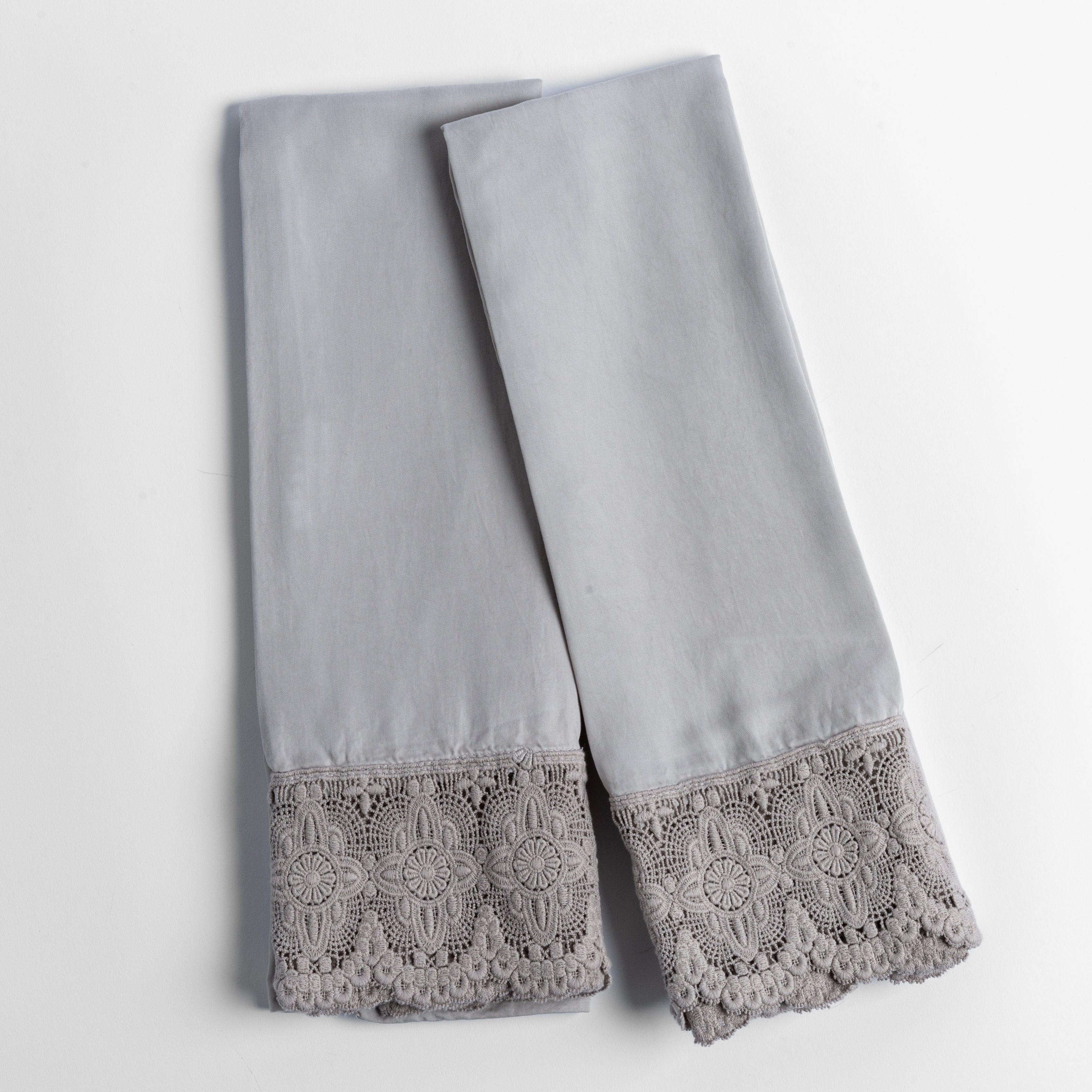 cotton lace trimmed tencel pillowcases folded and shot from overhead against a white background