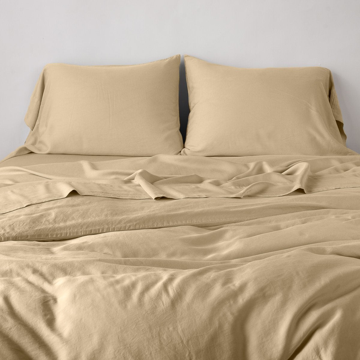 Honeycomb: duvet cover with matching sleeping pillows and sheeting against a white wall - end of bed view.