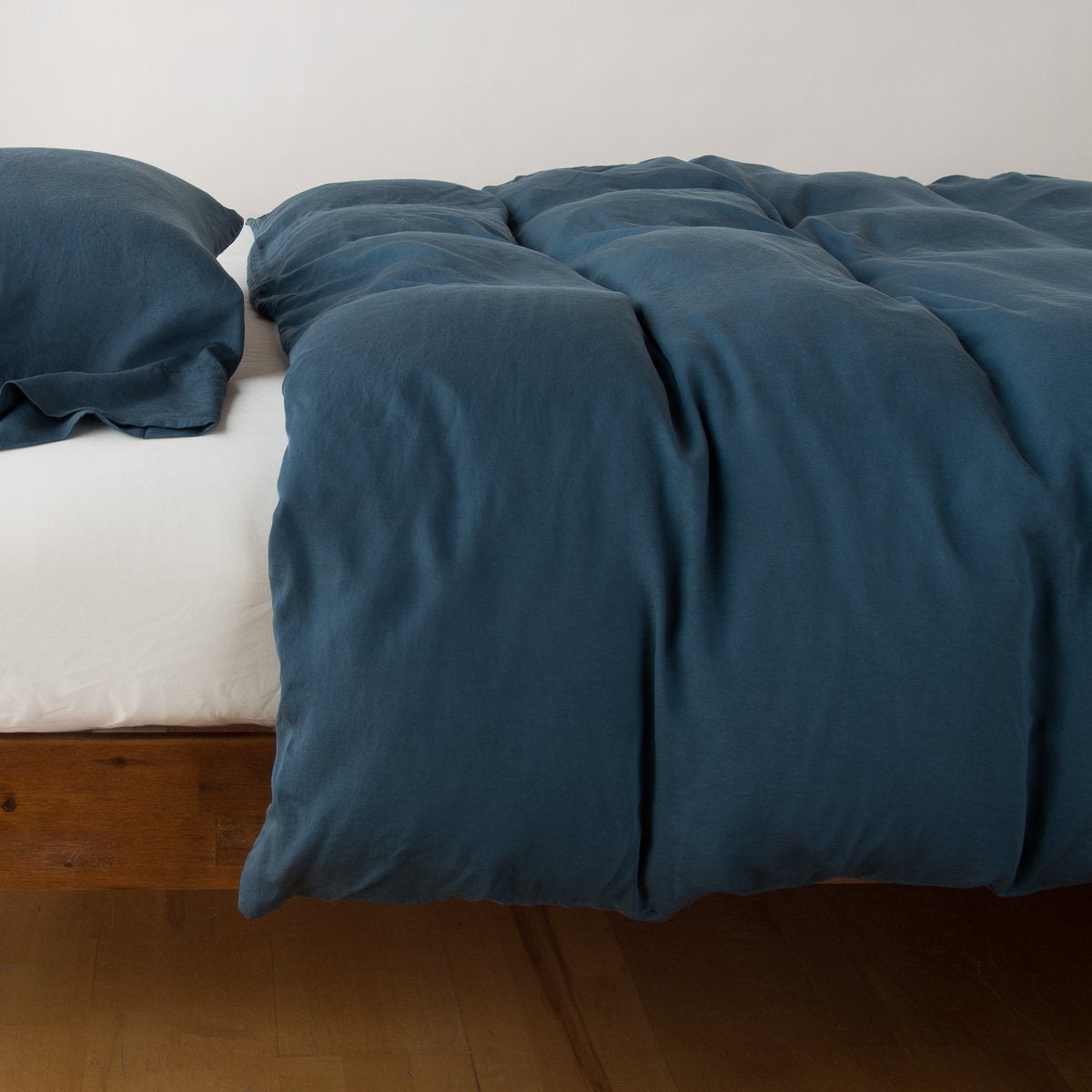 Midnight: duvet cover with matching sleeping pillow and fitted sheet - side view.