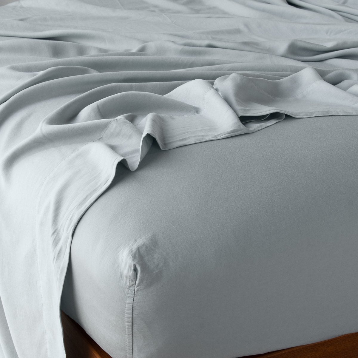 Mineral: fitted sheet with matching rumpled flat sheet - top corner view.
