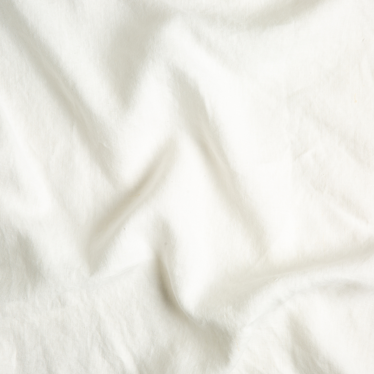 Winter White: A close up of midweight linen fabric in winter white, softer and warmer in tone than classic white.