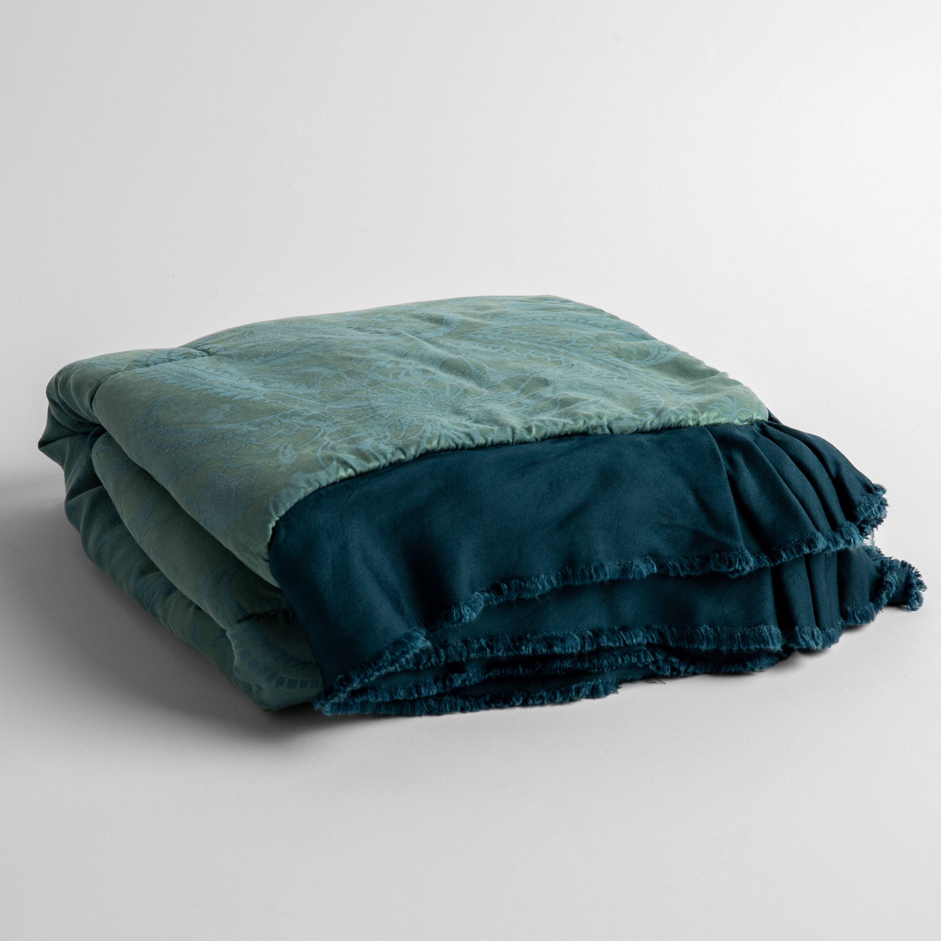 Cenote: a silk and tencel™ jacquard baby blanket folded and shot against a white background with the ruffled trim situated to be visible