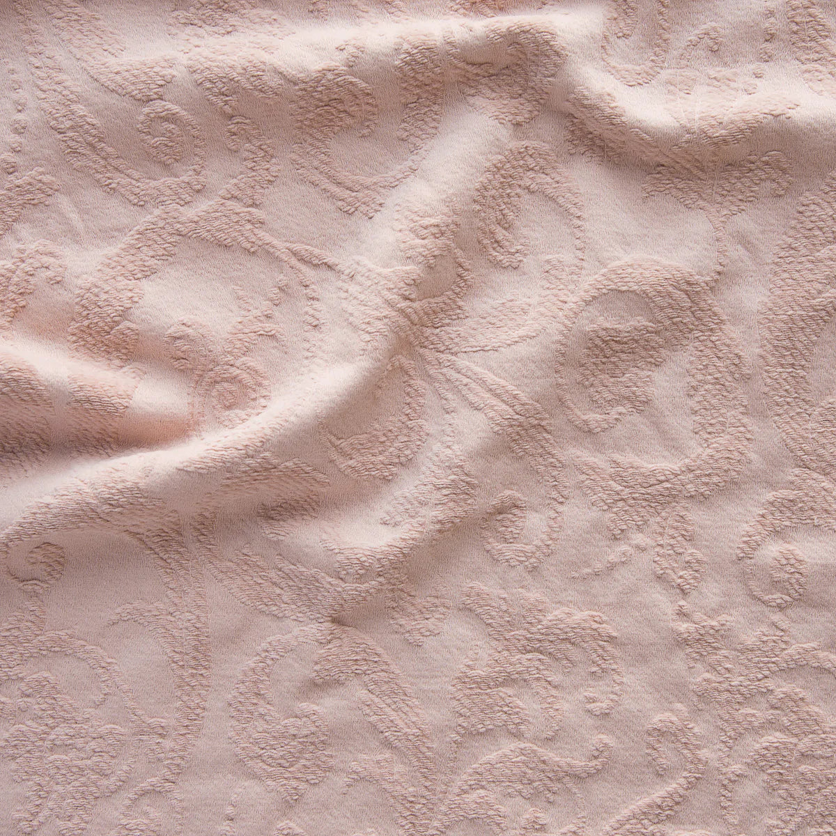 Rouge: A close up of Adele fabric in rouge, a mid-tone blush pink. The fabric is rumpled to show the cotton damask texture.