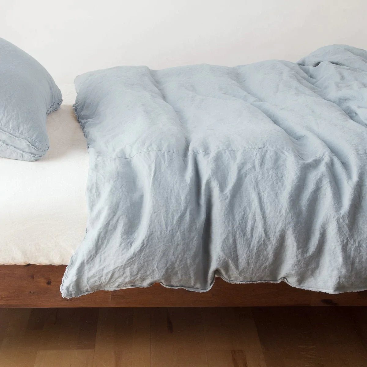 Mineral: Midweight linen duvet cover in mineral on a bed, side view.