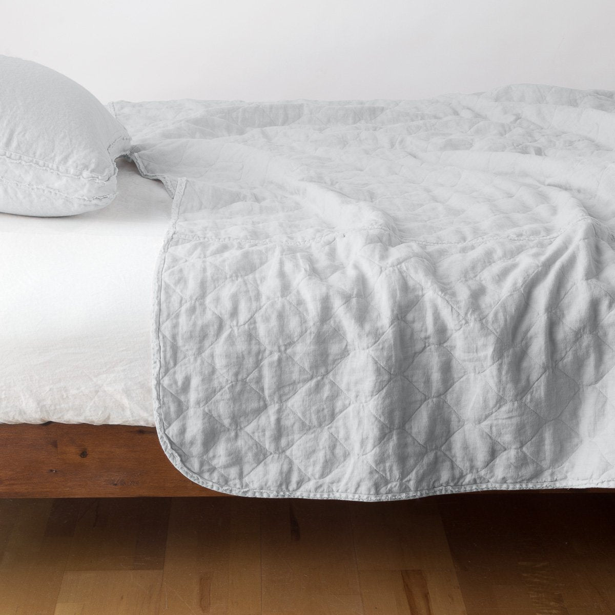 Sterling: quilted midweight linen coverlet on a bed - side view.