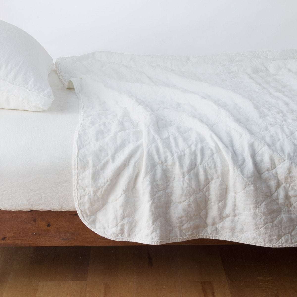 Winter White: quilted midweight linen coverlet on a bed - side view.