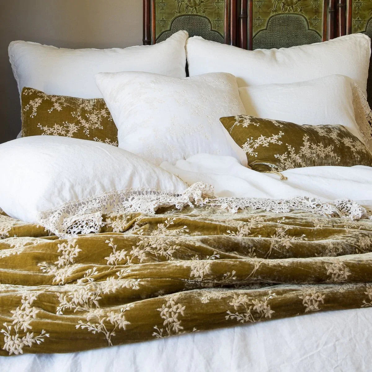: Winter white Austin shams layered behind winter white linen with cotton lace and rich gold embroidered silk velvet.
