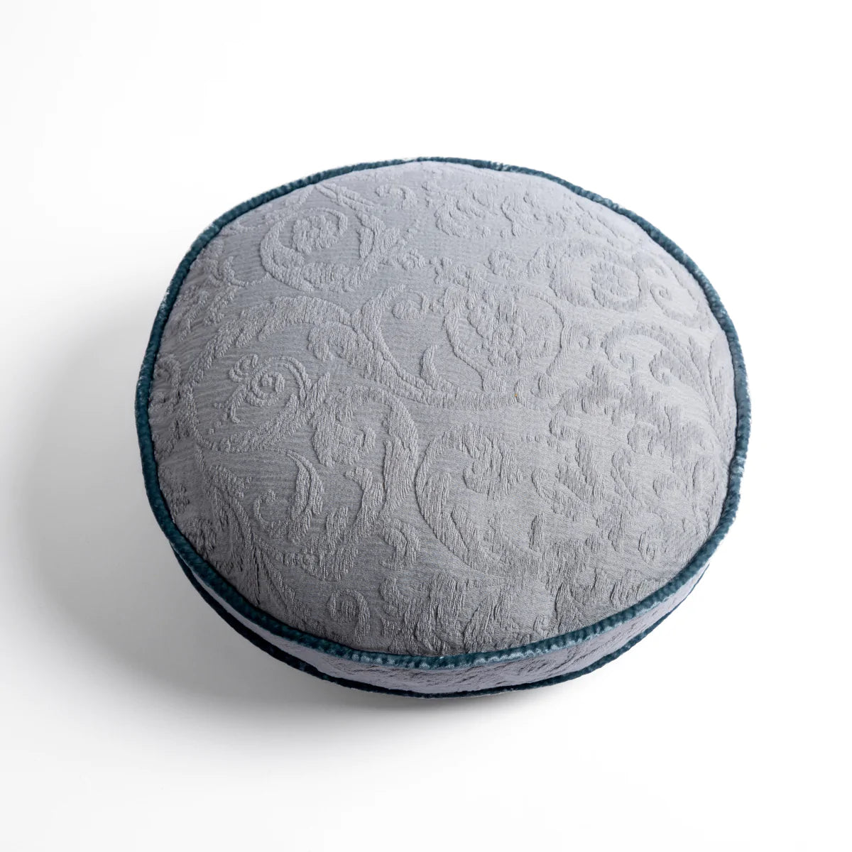 Mineral: Organic cotton damask round pillow with silk velvet trim on white background — overhead angle.